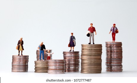 Miniature people standing on piles of different heights of coins. The concepts of person and wealth. - Shutterstock ID 1072777487