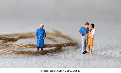 Miniature people standing with rope. The concept of conflict between mother-in-law and daughter-in-law.