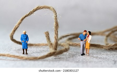 Miniature people standing with rope. The concept of conflict between mother-in-law and daughter-in-law.