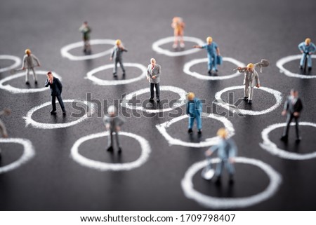 miniature people are standing in their own circle. Separated by default , Social distancing in the workplace during coronavirus (COVID-19)