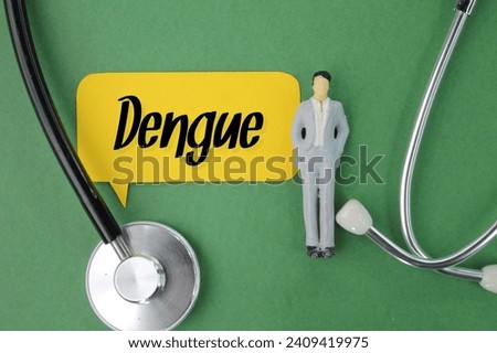 miniature people, stethoscopes and colored paper with the word Dengue