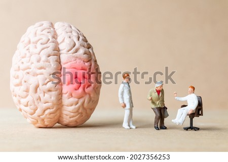Miniature people Surgeon spoke with patient about brain injuries. World Stroke Day concept.