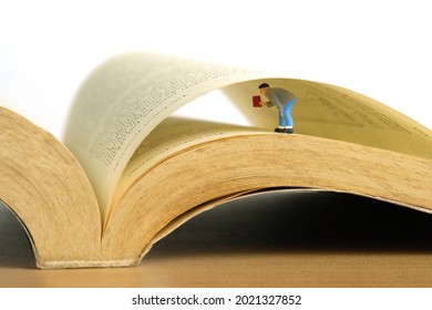 Miniature people toy figure photography. A men searching a data on opened book. Image photo