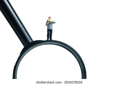 Miniature People Toy Figure Photography. A Men Student Standing Above Magnifier Glass, Isolated On White Background. Image Photo