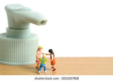 Miniature People Toy Figure Photography. Health Protocol On Pandemic Concept. A Group Of Kids Playing With Head Sanitizer Bottle. Image Photo