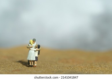 Miniature People Toy Figure Photography. Family Reunion Concept. Father Hugging His Wife And Daughter In The Desert. Image Photo