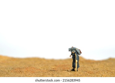 Miniature People Toy Figure Photography. An Old Men Grandfathers Walking Alone In The Desert, Moving To Refugee Camp Because Of War Conflict. Image Photo