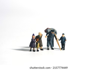 Miniature People Toy Figure Photography. A Group Of Poor Family Grandpa, Grandma, And Two Grandchildren Isolated On White Background. Image Photo