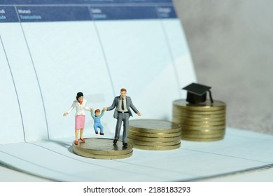 Miniature People Toy Figure Photography. Couple With Baby Child Walking Above Coin Money Stair To The Cap With Book Bank Account. Future Financial Plan For Education Concept. Image Photo