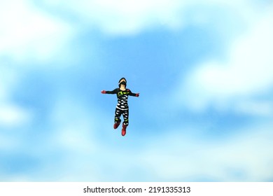 Miniature People Toy Figure Photography. A Men Doing Sky Diving Jump In Cloudy Bright Day. Image Photo