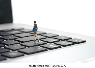 Miniature People Toy Figure Photography. A Businesswoman Standing Above Notebook Laptop Keyboard. Isolated On White Background. Image Photo