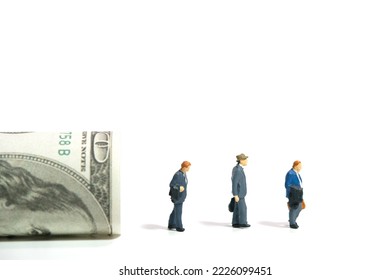 Miniature people toy figure photography. Severance pay for laid off workers concept. Three businessmen with rolled dollar money. Isolated on white background. Image photo