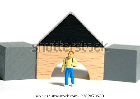 Miniature people toy figure photography. A boy kindergarten student playing Montessori wooden block. Isolated on white background. Image photo