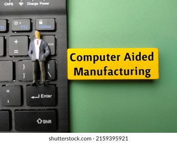 Miniature People And Wireless Keyboard With The Word Computer Aided Manufacturing.