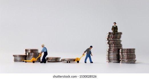 Miniature people at work site with stack coins. Concept of economic inequality.