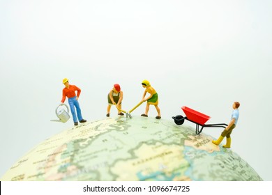 Miniature People : Worker are on the earth digging , cleaning and watering the earth use as take care of our world to protect greenhouse effect and planet lover concept.