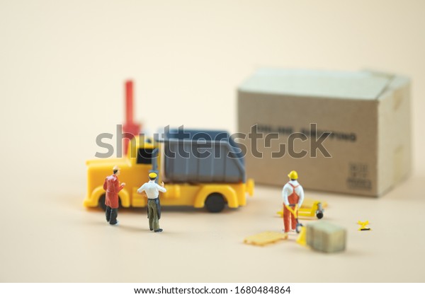Miniature people : Worker\
team moving order from online shopping. Concepts of logistics and\
transportation