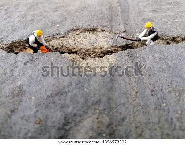 Miniature\
people : workers repairing Road repair\
concept