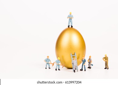 Miniature People Working With Golden Egg