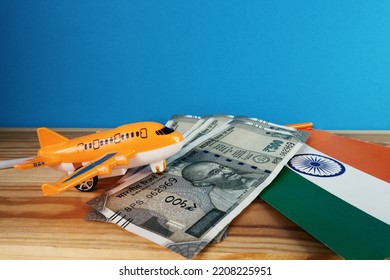 Miniature plane, rupees and Indian flag on the table. Concept of air travel in India.                  - Shutterstock ID 2208225951