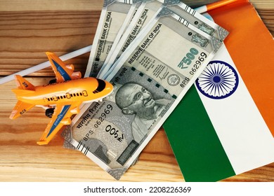 Miniature plane, rupees and Indian flag on the table. Concept of air travel in India. Top view. - Shutterstock ID 2208226369