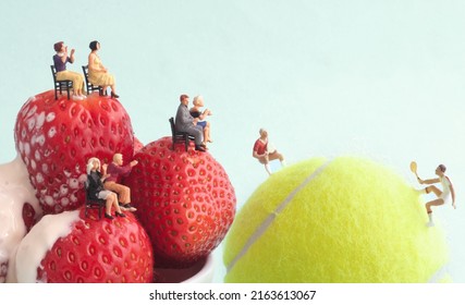 Miniature players on tennis ball with onlooking seated spectators on strawberries and cream, summer grass, wimbledon tennis concept