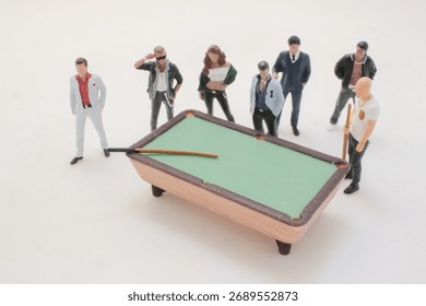 A miniature pool table surrounded by a diverse group of figurines,