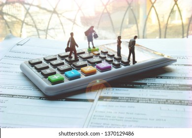 Miniature Professional Tax Accountant Or Preparer On Calculator. Blank Tax Forms Ready To Be Filled Out. Tiny Team Of Men And Women To Help With Your Personal Or Small Business Taxes. Hire A Pro.