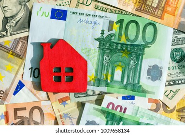 Miniature Red House On Cash Backround. Symbolic Image Of A Mortgage, Purchase Of Own Housing Or Rent.