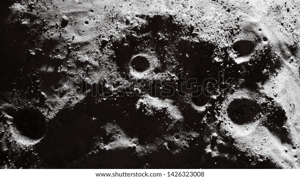 Miniature scale model of the Moon surface with its
craters, shoot in the studio set under small led lights, with wide
angle lens.