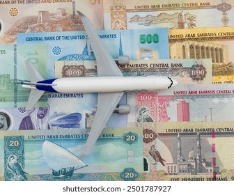 Miniature scale toy passenger aeroplane on emirates currency notes. - Powered by Shutterstock