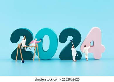 Miniature scene workers paint 2024 New Year - Shutterstock ID 2132862625