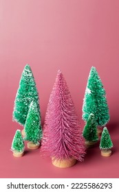 Miniature set model winter pine tree with snow and shiny is props decoration for create atmosphere Christmas. Christmas decor, christmas tree on pink background