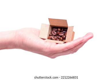 Miniature Shipping Box Full Of Roasted Coffee Beans In Hand Isolated On White Background. Handpicking A Coffee Supplier Concept.