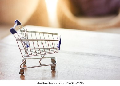 Miniature Shoping Cart On Wooden Table.