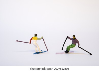 Miniature skier in action, white background, copy space - Shutterstock ID 2079812806