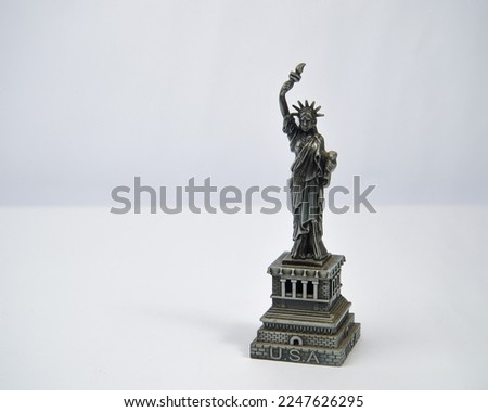 Miniature of the Statue of Liberty made of metal on a white background.