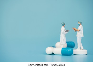 Miniature Support Team, Doctor Emergency Medical Team Wear Surgical Mask With Pills And Blue Sea Background. Health Care, Life Insurance For Covid-19 Concept. Report And Data Science