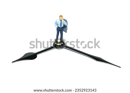Miniature tiny people toy figure photography. A businessman standing above clockwise. Isolated on white background. Image photo