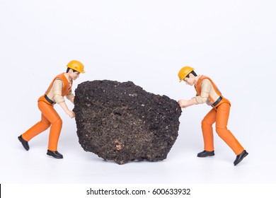 Miniature toy workers pulling a big rock - Powered by Shutterstock