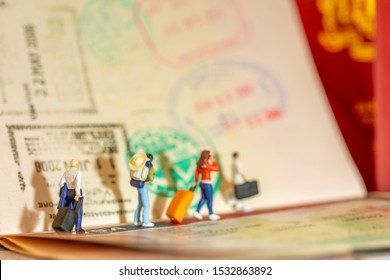 Miniature toys concept studio set up - expatriate business man arrives or departs with visa passport stamps as the background. Side lighting with vintage yellowish filter for evening sunset light.
