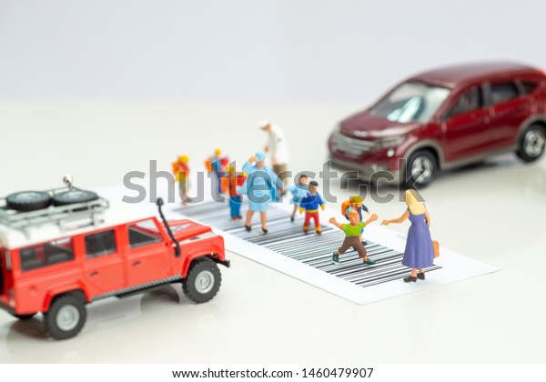 Miniature toys school kids walk on cross\
road bar code - school children road safety\
concept.