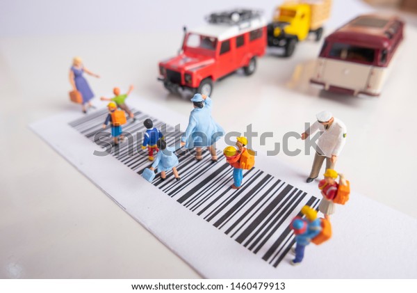Miniature toys school kids walk on cross\
road bar code - school children road safety\
concept.