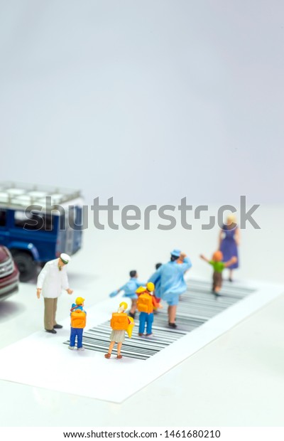 Miniature toys school kids\
walk on cross road bar code - school children road safety concept -\
top view\
