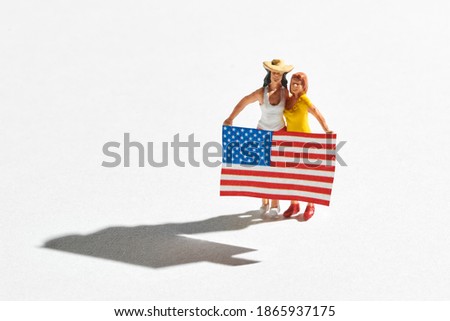 Miniature of two american women standing with flag. Demonstration participants, political campaign supporters concept. High angle view isolated on white background with shadow and copy space