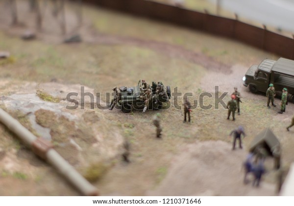 miniature, which shows the\
special forces soldiers on a cross-country car and a truck in the\
background