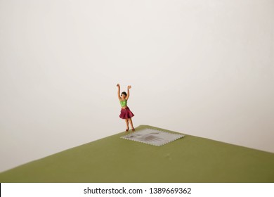 Miniature Woman Is Happy To Receive Card Or Letter. Pen Pal Or Snail Mail Concept. Keeping In Touch Via Old Fashioned Methods. Birthday Greetings Bring Joy. Tiny Girl With A Postage Stamp.