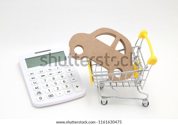 Miniature wooden
car, shopping cart and  calculator on white background.
Concept of
buying new car.
