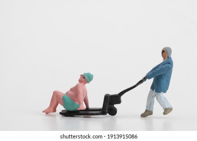 Miniature Of A Worker Carrying A Fat Man With Bathing Suit