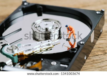Miniature worker or professional staff digging on HDD, hard drive using as data mining, data restore or fixing and repair computer hardware concept.